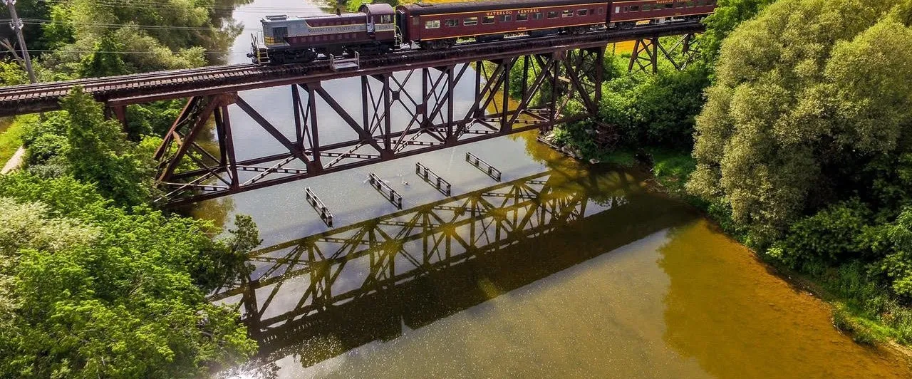 a train crossing a bridge over a body of water