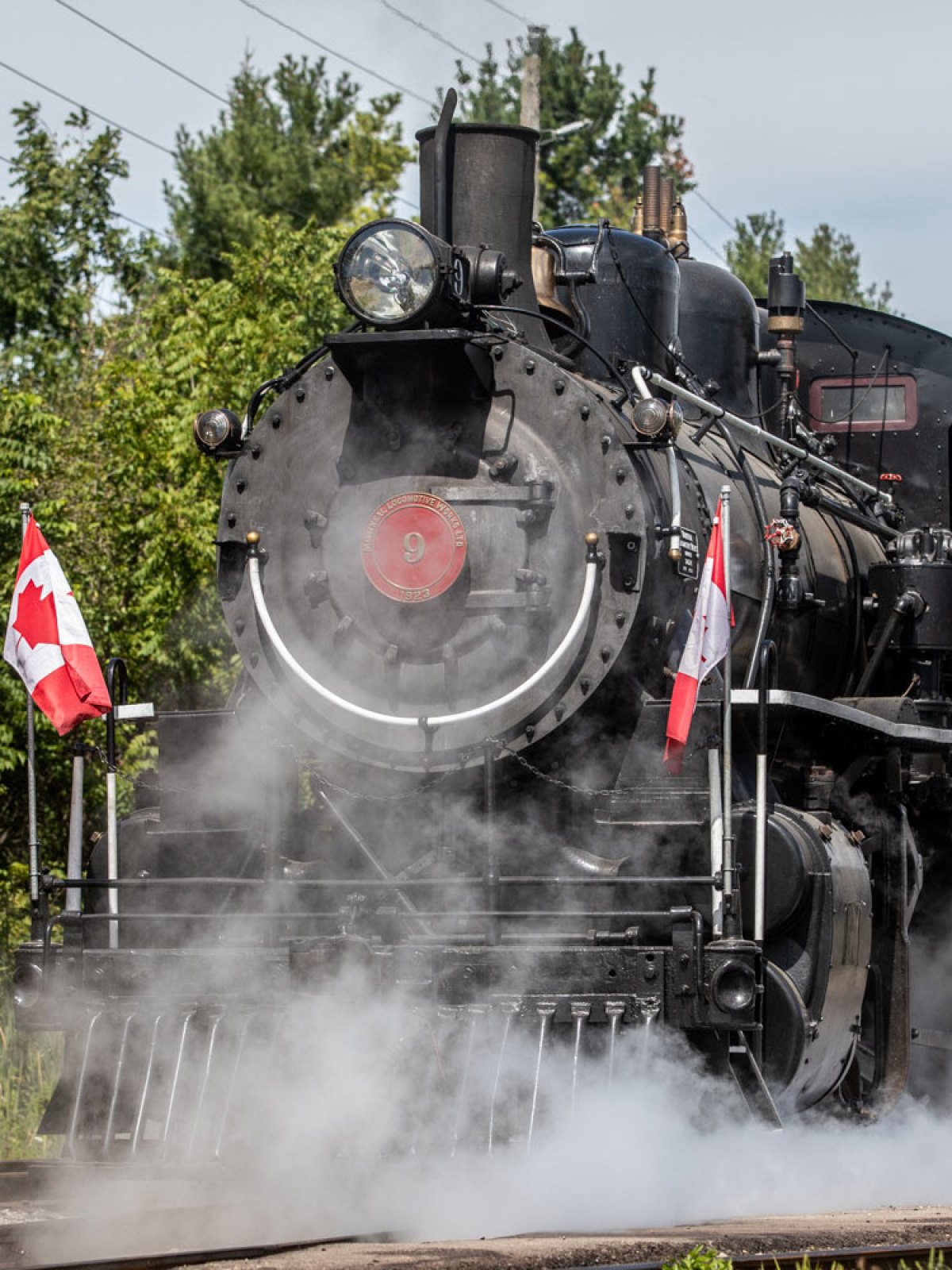 a steam train on a track with smoke coming out of it