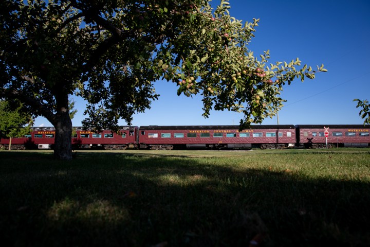 a large long train on a train track with trees in the background