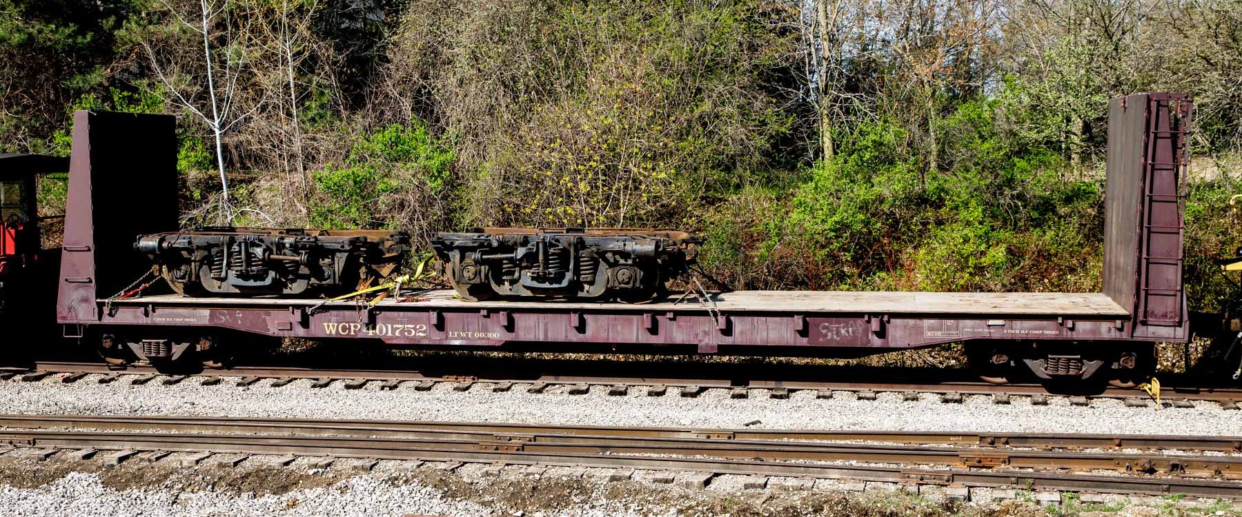 a large long train on a train track with trees in the background