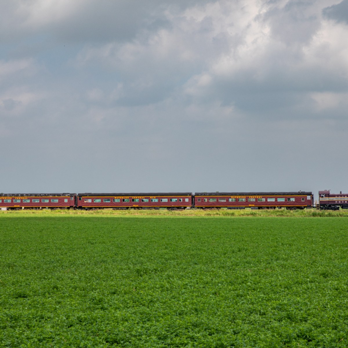 a train traveling down train tracks near a field