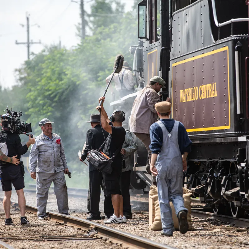 a group of people standing next to a train