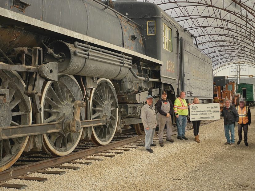 a group of people standing next to steam locomotive #1238
