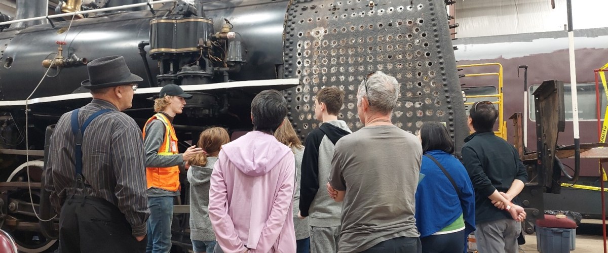 Jake explaining the work on the firebox to a group of visitors a group of people standing in front of a crowd