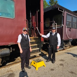 two men standing in front of a train