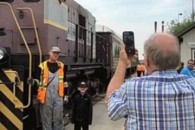 a group of people standing next to a train