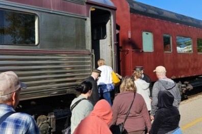 a group of people waiting to board a train