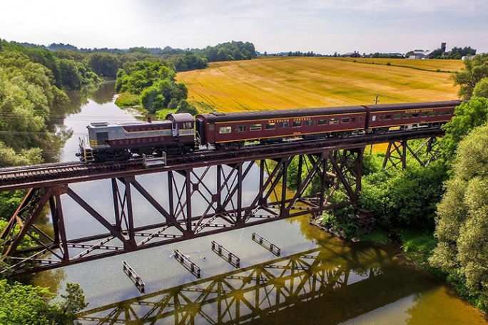 a train crossing a bridge over a body of water