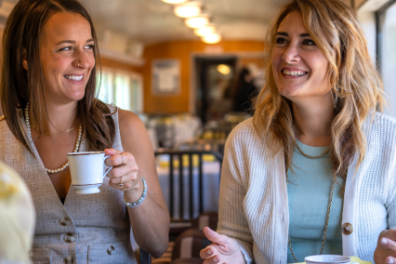 a woman sitting at a table with a cup of coffee