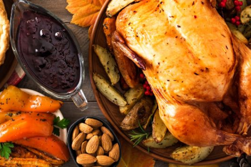 Thanksgiving feast with roasted turkey, pumpkin pie, corn, and autumn decor.