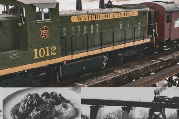 A train on a bridge with a green and yellow engine marked 'Waterloo Central' and red passenger cars.