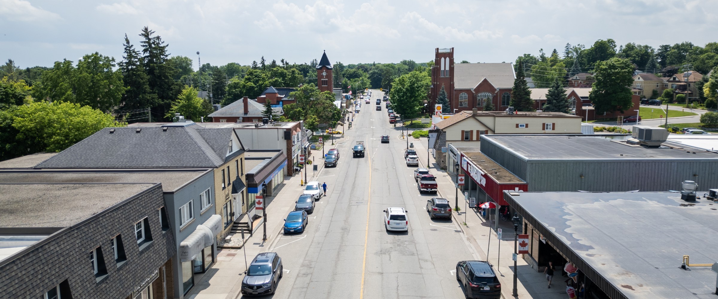 Aerial view of a small town street with cars and buildings.