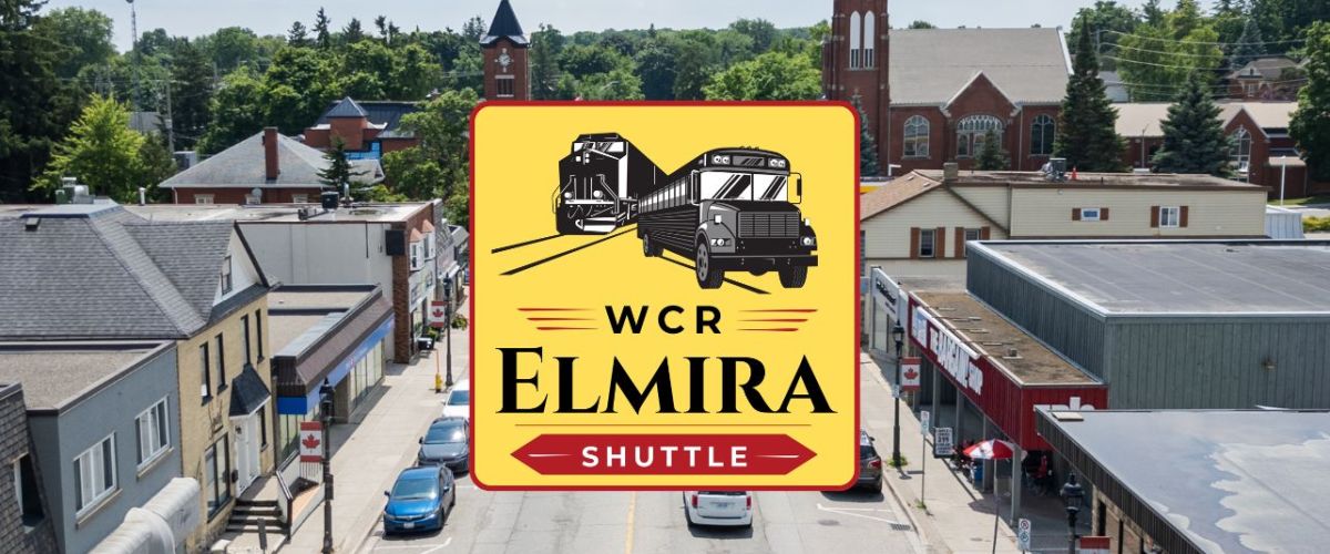 Street scene in Elmira with a shuttle sign in the foreground.